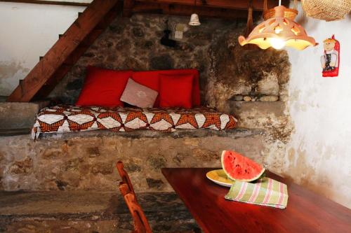 a bedroom with a bed and a table with a plate of watermelon at Traditional Cycladic house in Serifos Chora