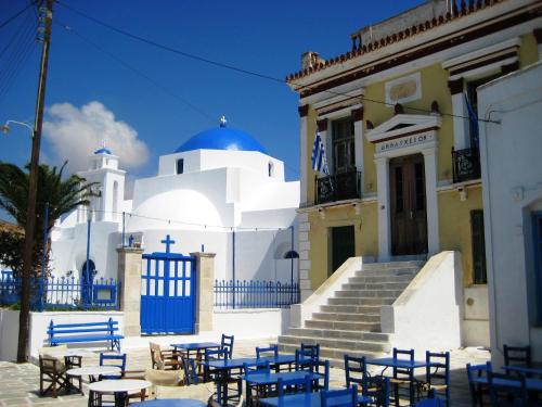 a group of tables and chairs in front of a building at Traditional Cycladic house in Serifos Chora