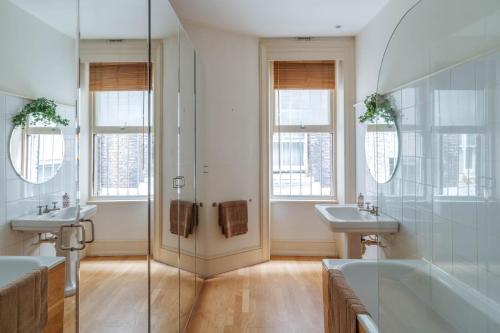 a bathroom with two sinks and a shower at Bright Space in the Heart of London in London
