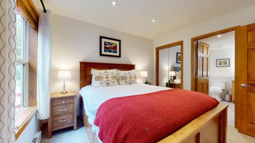 ein Schlafzimmer mit einem großen Bett mit einer roten Decke in der Unterkunft Beautiful Golf Course Setting by Harmony Whistler in Whistler