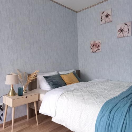 um quarto com uma cama e uma mesa com um candeeiro em Narva Relax Apartment em Narva