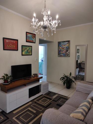 a living room with a couch and a tv at Casa 2 quartos com churrasqueira no centro de Serra Negra in Serra Negra
