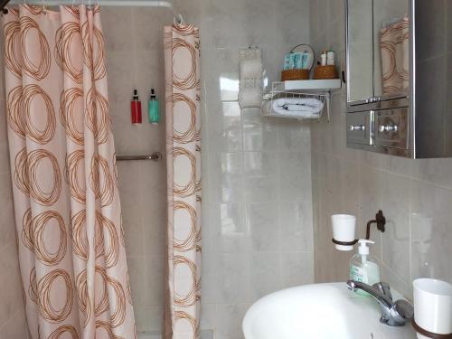 y baño con cortina de ducha y lavamanos. en Casa Berna, en Masca