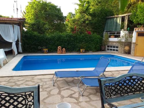 uma piscina com duas cadeiras e uma mesa em la Vega Fuente las moreras em La Iruela