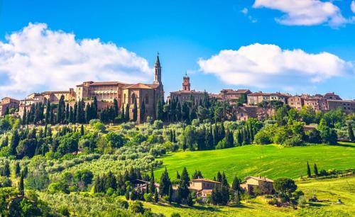 a large castle on top of a green hill at PienzaLettings "Casa Gioia" in Pienza