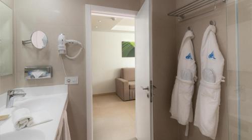 a bathroom with a sink and a shower with towels at Marina Elite in Patalavaca