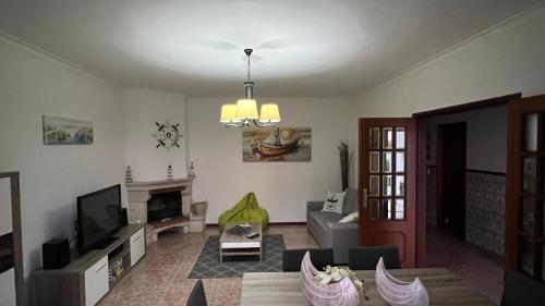 een woonkamer met een bank en een televisie bij West coast dream Nazare in Nazaré