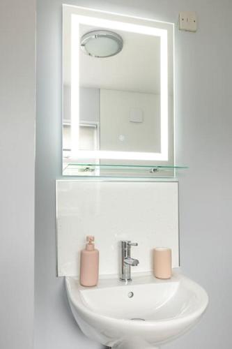 a bathroom sink with a mirror and a sink at Fair Haven - Off Street Parking and Garden in Shrewsbury