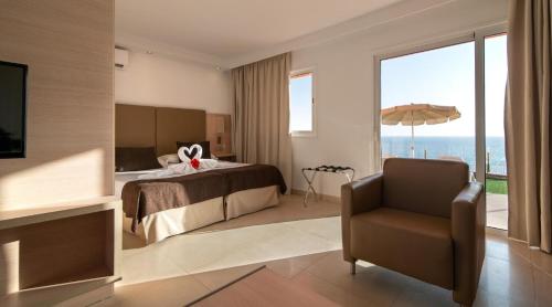 Habitación de hotel con cama y silla en Marina Elite, en Patalavaca