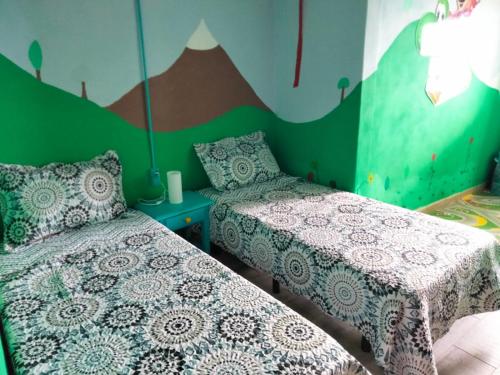 a bedroom with two beds and a mountain mural at Casa de Campo Lomo del Balo in Guía de Isora