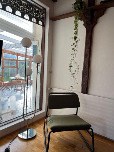 a chair sitting in a room next to a window at House with a magical garden and sunroom in Höfn