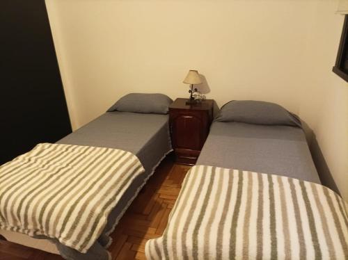 two beds sitting next to each other in a room at Caballito deluxe Apart in Buenos Aires