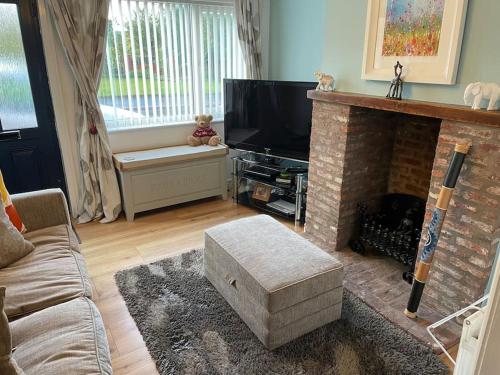 a living room with a fireplace and a television at Beautiful home perfect for families&professionals in Nantwich