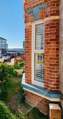 a window on the side of a brick building at Sandy feet retreat in Exmouth