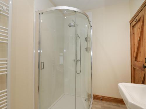 a shower with a glass door in a bathroom at Foulsyke Farm Cottage in Saltburn-by-the-Sea