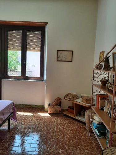 um quarto com uma janela e uma estante de livros em Sweet Home em Oliena