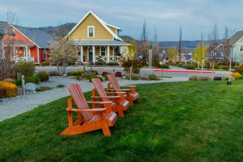 four chairs sitting in the grass in front of a house at Brass Monkey #74 in Chelan