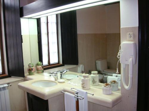 a bathroom with a sink and a large mirror at Quarto Duplo - Monte dos Arneiros in Lavre