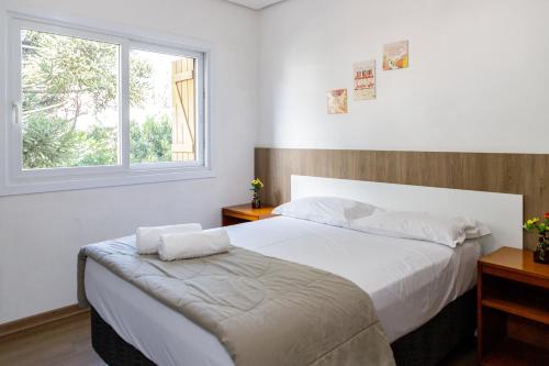 a bedroom with a large bed and a window at Lindo residencial no centro de Gramado in Gramado
