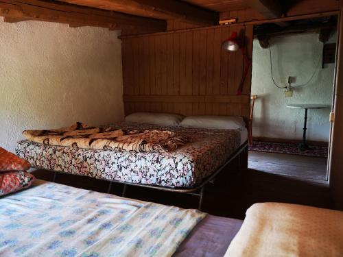 a bedroom with two beds in a room at Pinnettu sardo casa di campagna in ecosistema insetti e animaletti simpatici in condivisione,Leggere attentamente Prima di prenotare in Oliena