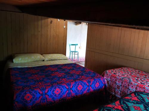 a bedroom with two beds and a table in the window at Pinnettu sardo casa di campagna in ecosistema insetti e animaletti simpatici in condivisione,Leggere attentamente Prima di prenotare in Oliena