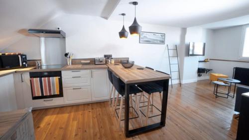 a kitchen with a island in the middle of a room at Coup de Cœur assuré pour ce T2 rénové Hyper centre in Biarritz