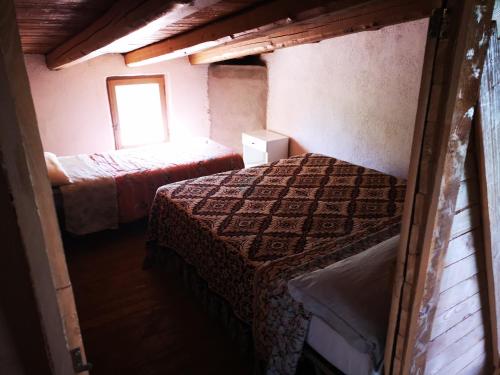 a small room with two beds and a window at Pinnettu sardo casa di campagna in ecosistema insetti e animaletti simpatici in condivisione,Leggere attentamente Prima di prenotare in Oliena