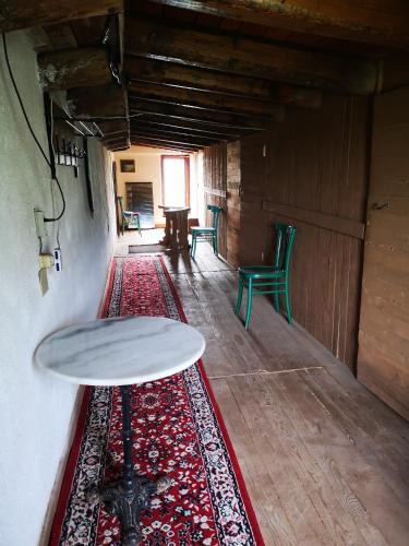 a room with a table and rugs on the floor at Pinnettu sardo casa di campagna in ecosistema insetti e animaletti simpatici in condivisione,Leggere attentamente Prima di prenotare in Oliena