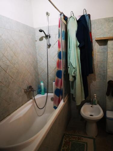 a bathroom with a tub and a toilet and a sink at Pinnettu sardo casa di campagna in ecosistema insetti e animaletti simpatici in condivisione,Leggere attentamente Prima di prenotare in Oliena