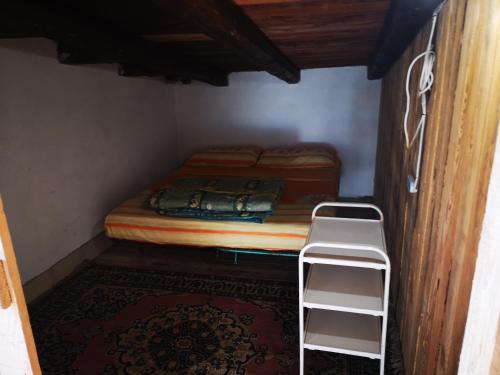 a small room with a bed and two white shelves at Pinnettu sardo casa di campagna in ecosistema insetti e animaletti simpatici in condivisione,Leggere attentamente Prima di prenotare in Oliena