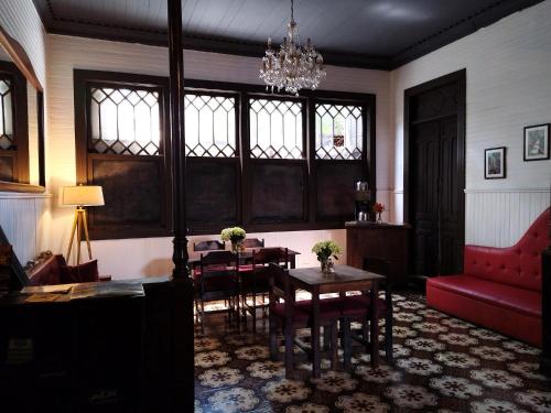 sala de estar con mesa, sillas y sofá rojo en Casa Aldea, en San José