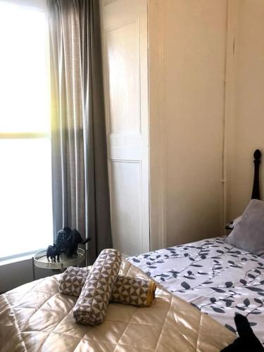 een slaapkamer met een bed met kussens en een raam bij City Studio in Swansea