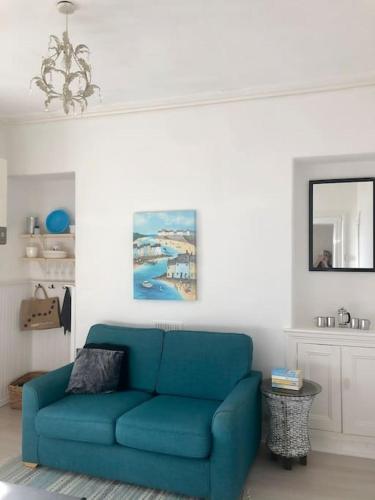 a blue couch in a living room with a mirror at City Studio in Swansea