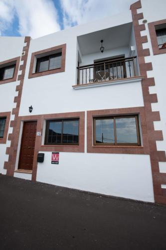 a white house with a balcony with a dog on it at Chávez Padrón in Frontera