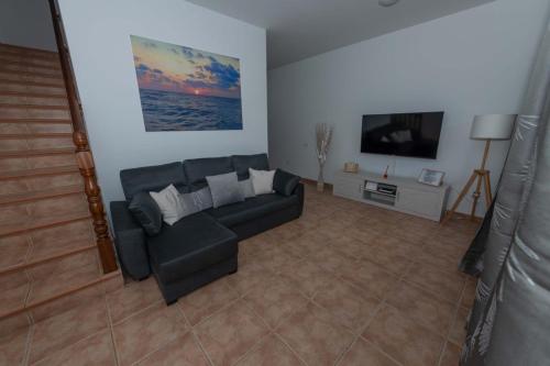 sala de estar con sofá y TV de pantalla plana en Chávez Padrón, en La Frontera