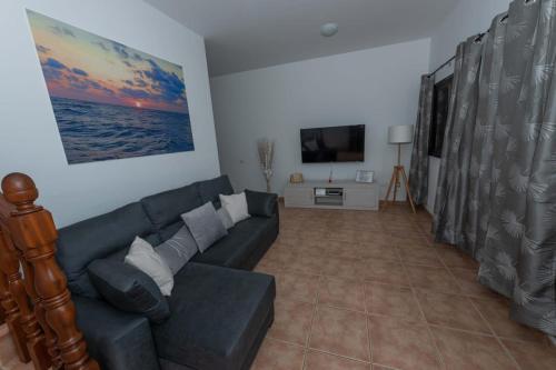 sala de estar con sofá y TV en Chávez Padrón, en La Frontera
