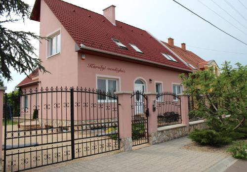 a pink house with a black fence at Károlyi Panzió in Eger
