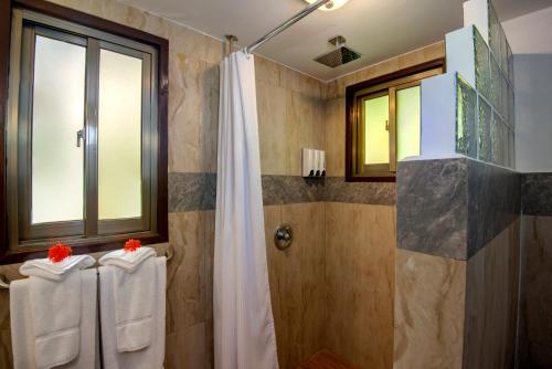 ein Bad mit einer Dusche und einem Duschvorhang in der Unterkunft Palau Carolines Resort in Koror
