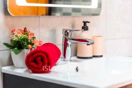 a bathroom sink with a red towel next to a faucet at Oceanfront Holiday with Stunning Views in San Miguel de Abona