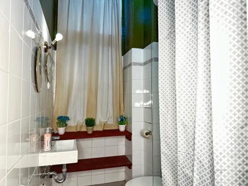 uma casa de banho com um chuveiro, um WC e uma janela. em Studio Apartment in attraktiver und zentraler Lage em Berlim