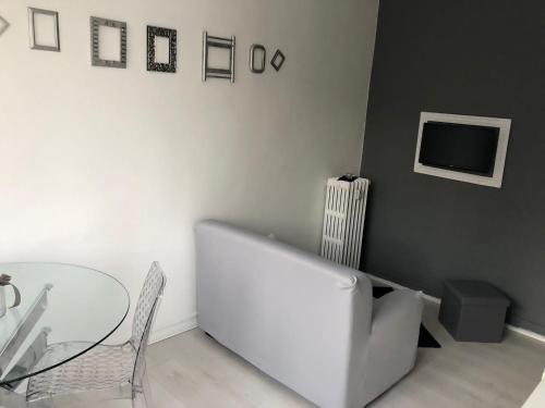 een woonkamer met een witte bank en een glazen tafel bij Appartamento Farfalla Sara pala inalpi in Turijn