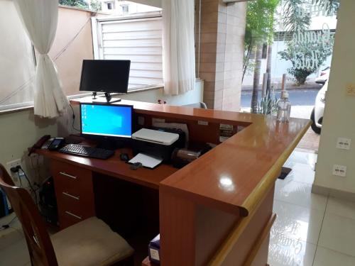 una oficina con un escritorio con un ordenador. en Novo Grande Hotel, en Ribeirão Preto