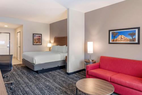 Habitación de hotel con cama y sofá rojo en Best Western Plus Desert View Inn & Suites, en Cathedral City