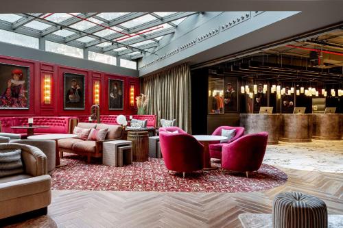 a lobby with red chairs and tables and a bar at Radisson RED Madrid in Madrid