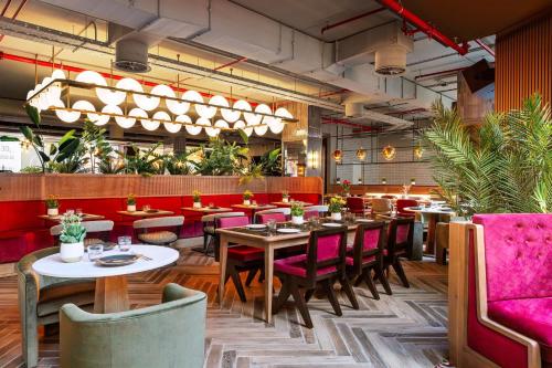 a restaurant with tables and chairs and plants at Radisson RED Madrid in Madrid