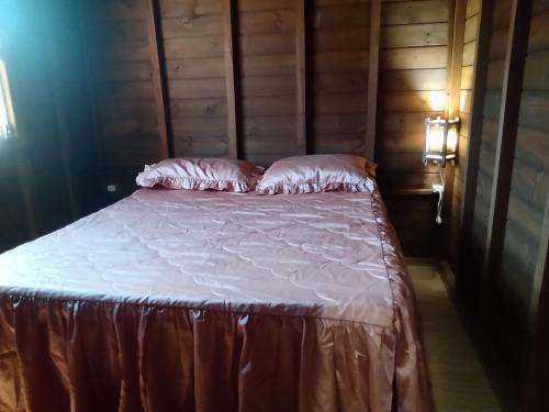 a bed with white sheets and pillows in a room at Cabanas Alamanda do Rosa in Imbituba