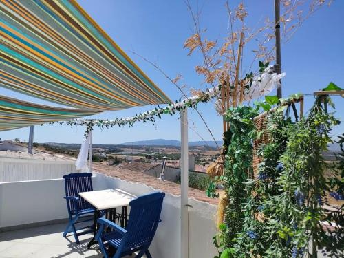 a patio with a table and chairs on a roof at Casa da Muralha in Estremoz