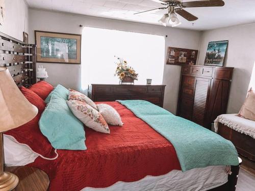um quarto com uma cama com almofadas vermelhas e azuis em Quiet Farmhouse close to major theme parks em Ridge Manor