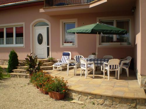 a patio with a table and chairs and an umbrella at Károlyi Panzió in Eger