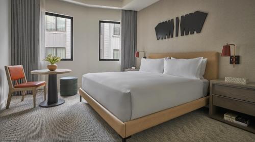 a bedroom with a large white bed and a table at Pendry Park City in Park City